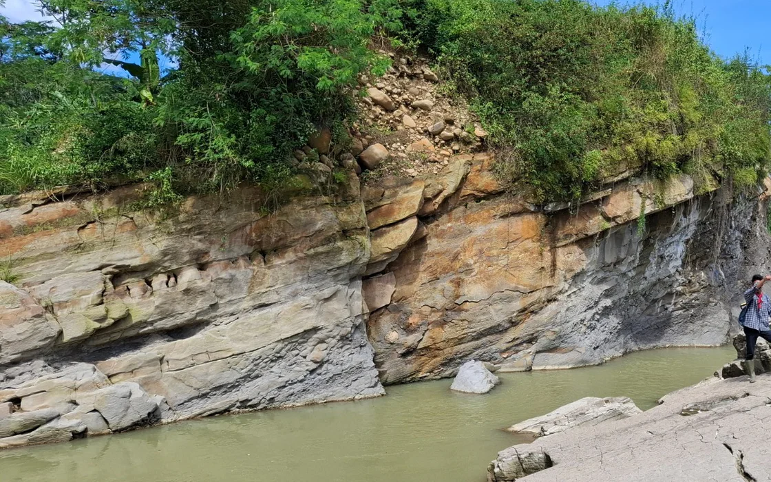 A river-cut gorge exposing tilted, layered rock faces during field observation